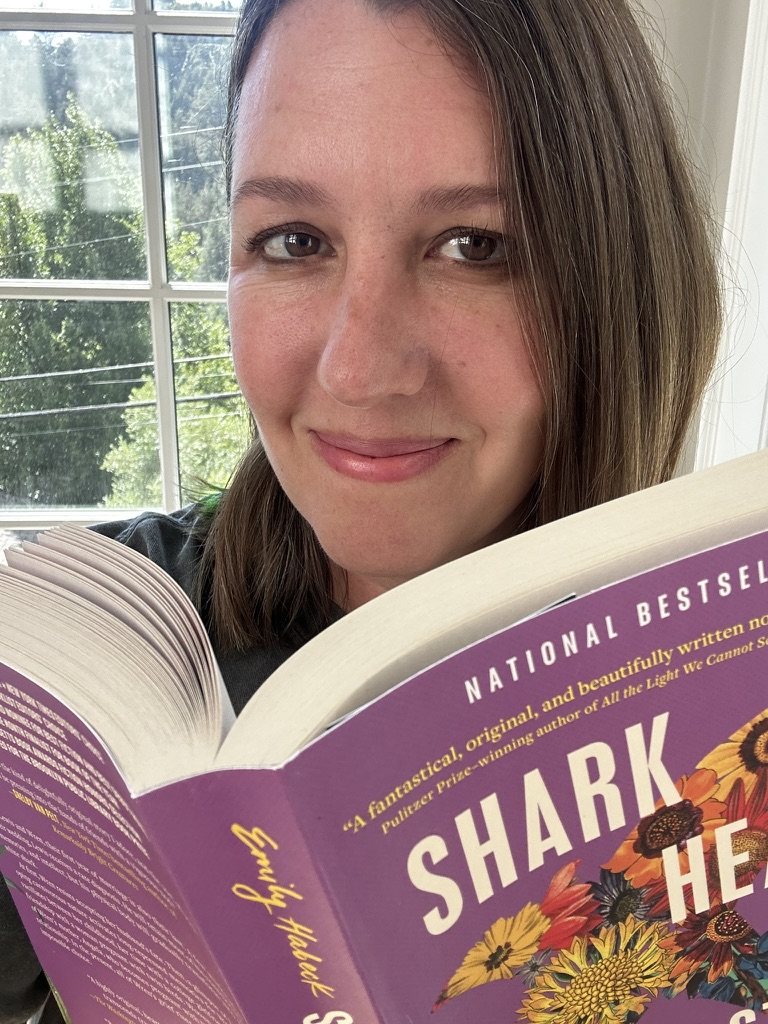 Carrie smiling while reading a book
